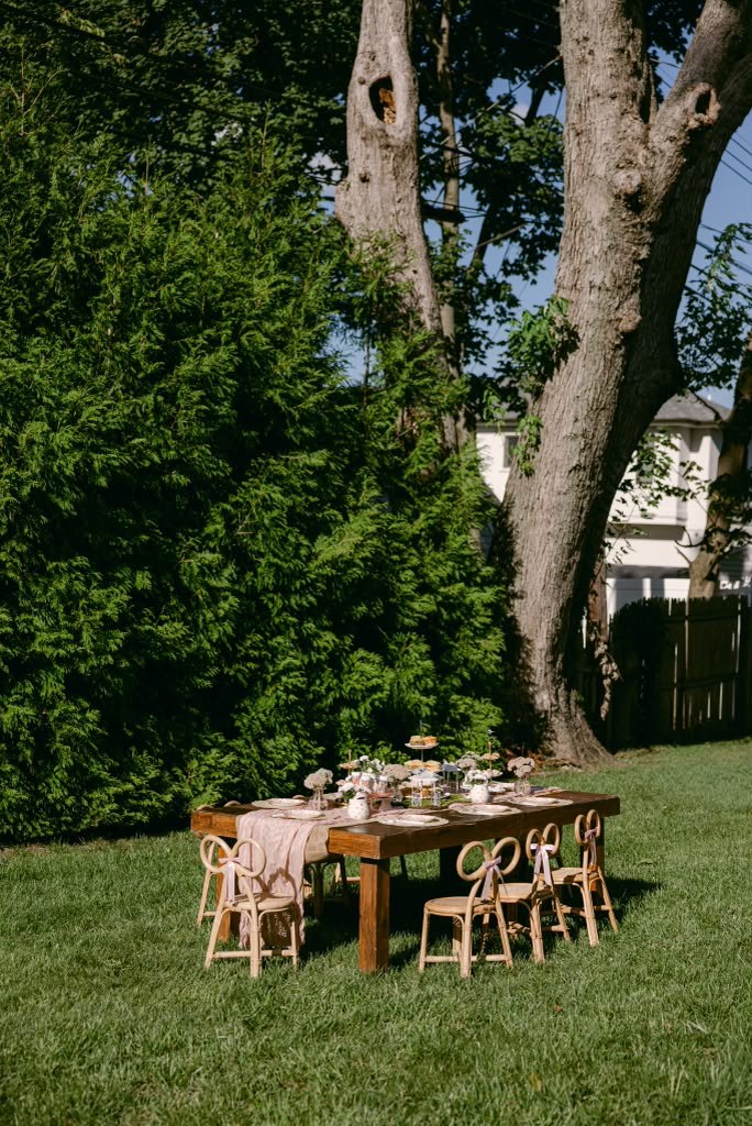 Kids' party table styled for a garden celebration with natural rattan chairs